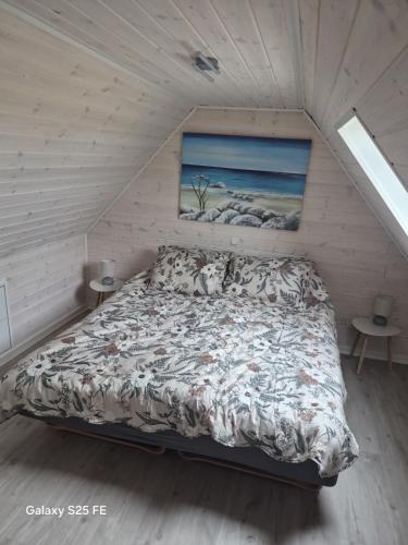 a bedroom with a bed in a attic at Ferielejlighed Solbakke in Østermarie