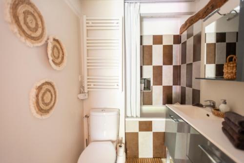 a bathroom with a toilet and a sink at La petite maison CARRÉ in Talant