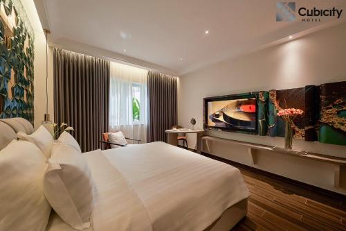 a hotel room with a large bed and a flat screen tv at Cubicity Hoang Dieu in Ho Chi Minh City