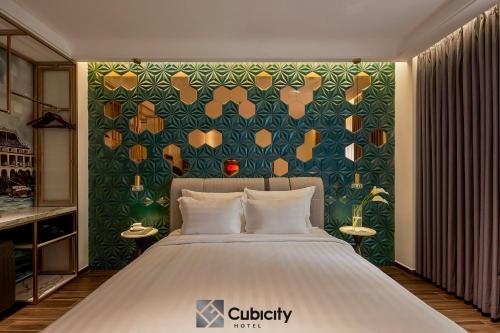 a bedroom with a bed and a green wall at Cubicity Hoang Dieu in Ho Chi Minh City