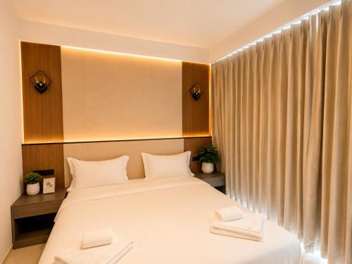 a bedroom with a bed with two white towels on it at Happy Room 3 in Pattaya South