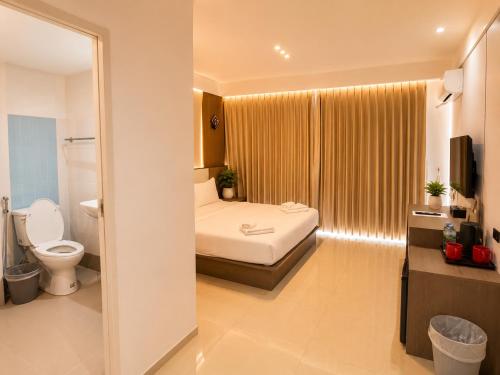 a hotel room with a bed and a toilet at Happy Room 3 in Pattaya South