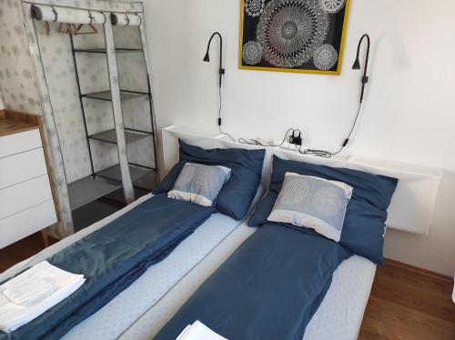 a bedroom with two beds with blue pillows at Apartman Garami Porta in Mezőkövesd