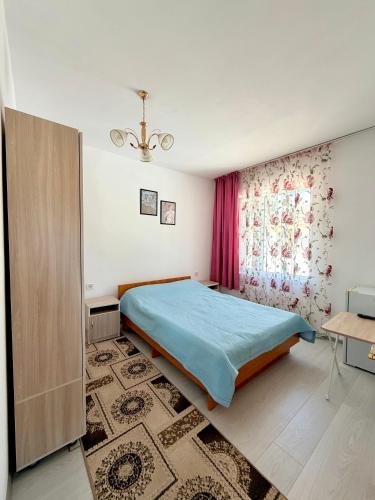 a bedroom with a bed and a window at Jibek Murok in Bosteri