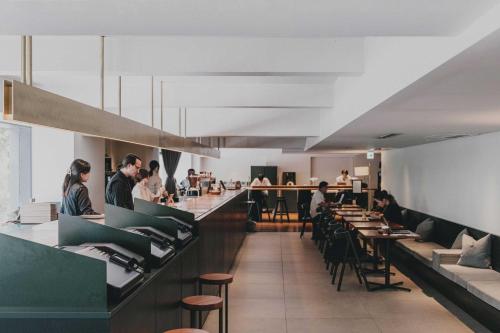 a restaurant with people sitting at a bar at DDD HOTEL in Tokyo