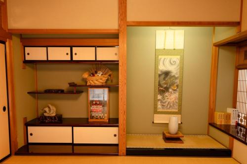 a kitchen with white cabinets and a shelf at Villa Taniguchi in Takayama