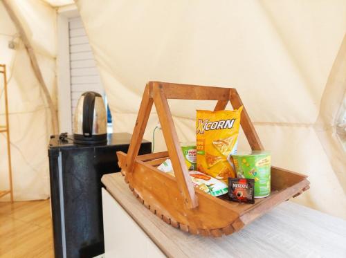 a wooden tray with food and snacks on a table at Maple Dome Glamping in Bandung