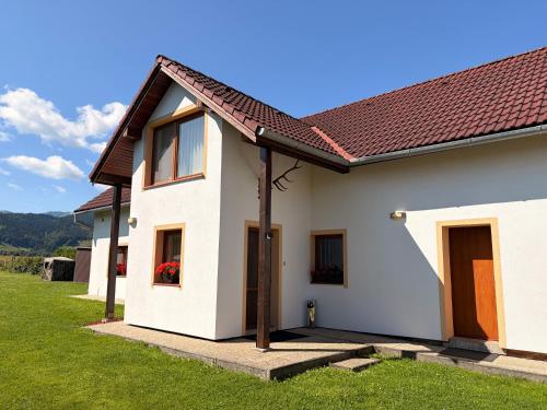 a white house with a red roof at Penzion Mlynárov Dvor in Dúbrava
