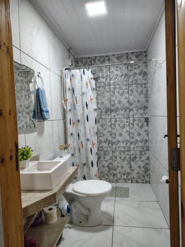 a bathroom with a toilet and a shower and a sink at Sítio Casa Verde in Uruguaiana