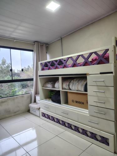 a room with white shelves and a large window at Sítio Casa Verde in Uruguaiana
