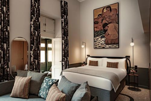 a bedroom with a bed and a couch at Romègas Hotel in Valletta