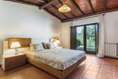 a bedroom with a bed and a large window at Refúgio da Nelinha in Rio Caldo