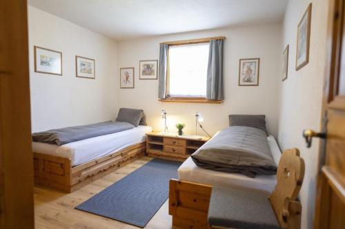 two twin beds in a room with a window at Chasa Munt Plan in Scuol