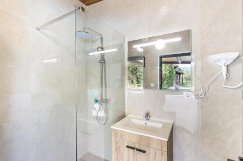 a bathroom with a sink and a glass shower at Refúgio da Nelinha in Rio Caldo