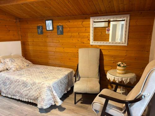 a bedroom with a bed and a chair in a cabin at Camping Torremolinos in Torremolinos
