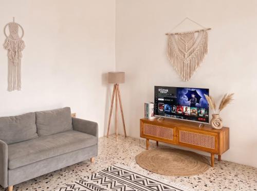 a living room with a couch and a tv on a table at Hanara Bohemian Villa in Bandung