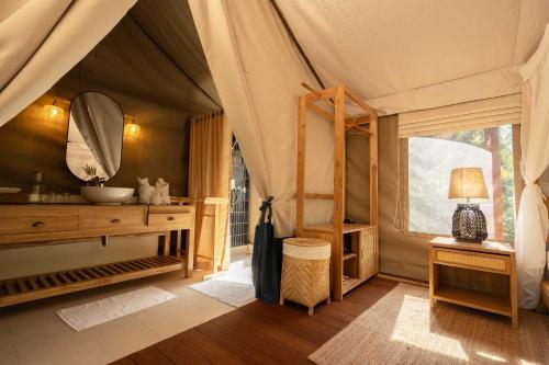 a room with a tent with a sink and a mirror at Visama Explorer Nan in Ban Huai Luk