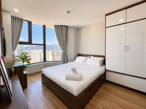 a bedroom with a large bed and a large window at 2-3 bedroom at HUD building Nha Trang in Nha Trang