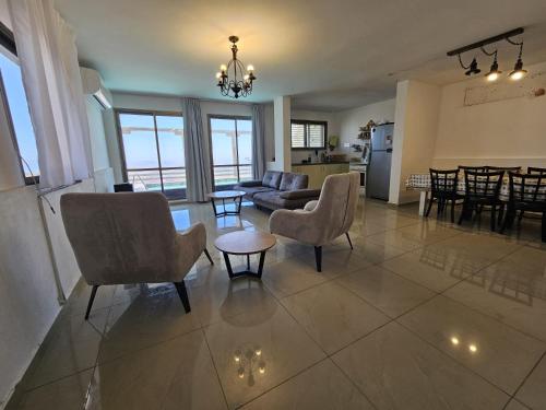 a living room with a couch and chairs and a table at Kinneret view with pool in Safed
