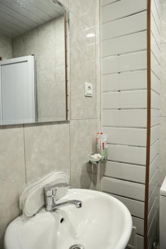 a bathroom with a white sink and a mirror at Liga Hotel and Restaurant in Shinuhayr