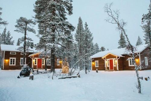 a log cabin in the snow in front at ELK Aurora Lodge in Kakslauttanen