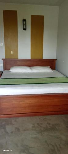 a large wooden bed in a bedroom at Lotus villa lake resort in Matara
