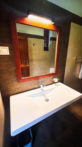 a bathroom with a white sink and a mirror at Lotus villa lake resort in Matara