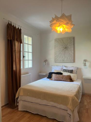 a bedroom with a large bed and a chandelier at Le Verger in Aix-en-Provence