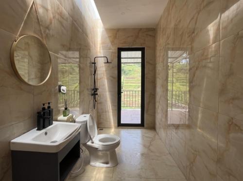 a bathroom with a sink and a toilet and a mirror at Private Cabin in Bandung