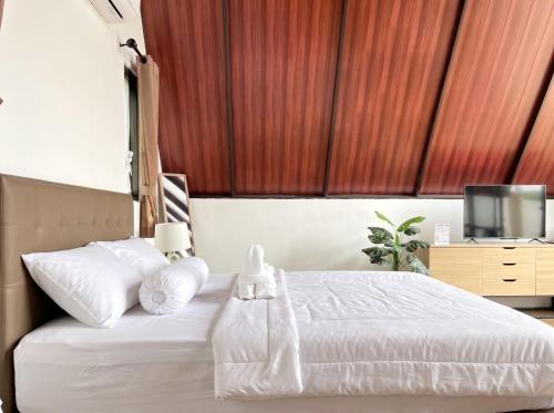 a bedroom with a bed with white sheets and a tv at Heavenly 2 - Private Triangle in Bandung