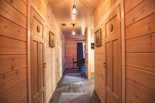 a hallway with wood paneled walls and a table at ELK Aurora Lodge in Kakslauttanen