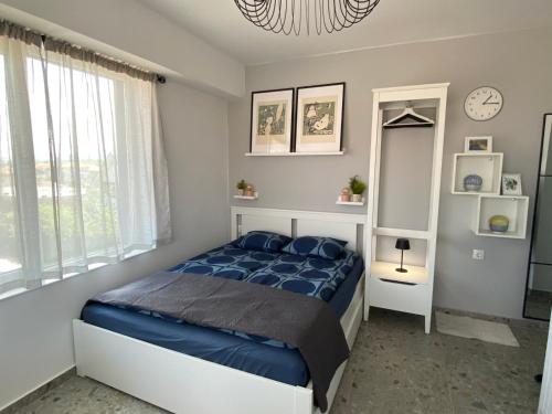 a bedroom with a bed and a clock on the wall at Студио Larimar in Lozenets