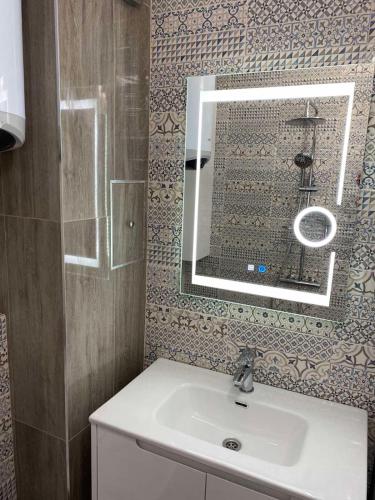 a bathroom with a sink and a mirror at Студио Larimar in Lozenets
