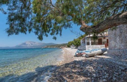 a group of boats on a beach next to a house at Breeze in Koumeika
