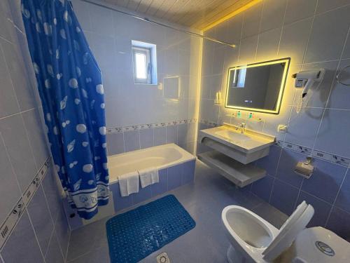 a bathroom with a sink and a toilet and a tub at Porso Boutique Hotel in Bukhara