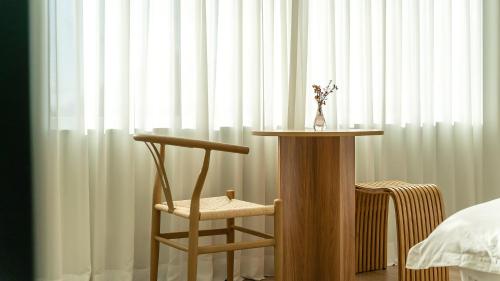 a chair and a table in front of a window at Namhae U9Stay in Namhae