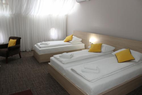 a hotel room with two beds and a chair at Hotel Story in Sarajevo