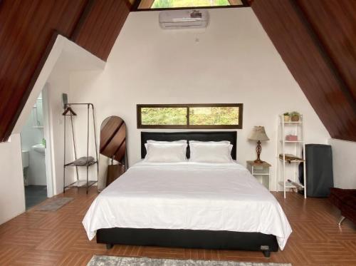 a bedroom with a large white bed with a window at Himalaya 2 - Private Triangle in Bandung