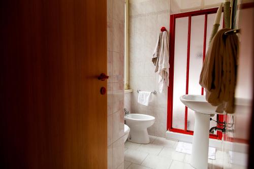 a bathroom with a toilet and a sink and a window at Hotel Altavilla 9 in Rome