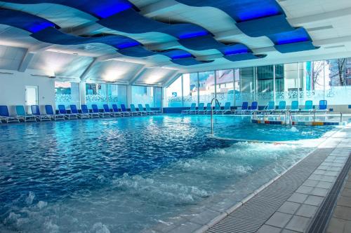 a swimming pool with blue lights on the ceiling at Hotel Cerkno in Cerkno