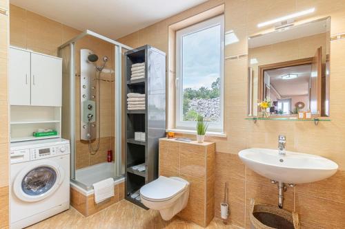a bathroom with a sink and a washing machine at Sunny Day self check in in Rijeka