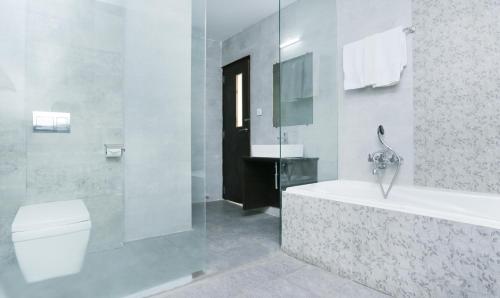 a bathroom with a tub and a toilet and a sink at Hotel Sunrise Luxury Stays in Chikmagalūr