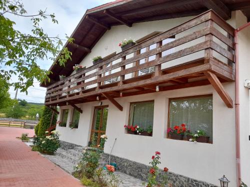 a building with flower boxes on the windows at Casa cu flori in Bîrsău