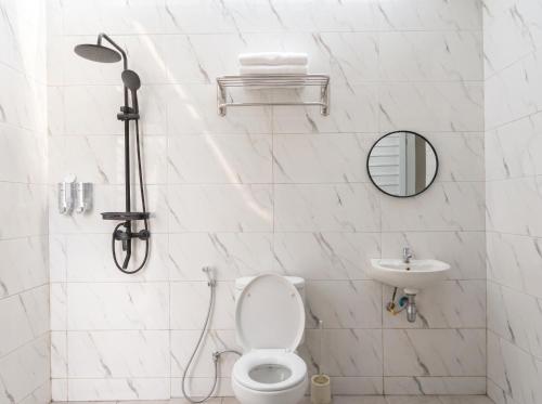 a white bathroom with a toilet and a sink at Azalea 1 - Private Dome in Bandung