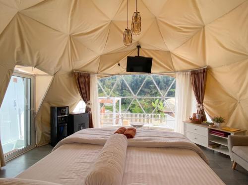 a bedroom with a large tent with a large window at Azalea 1 - Private Dome in Bandung