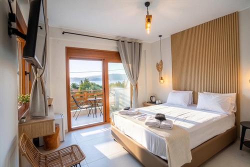 a bedroom with a large bed and a balcony at seaandolive in Ammouliani