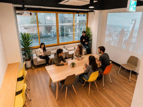 a group of people sitting around a table in a room at Tokyo Guesthouse HIVE in Tokyo