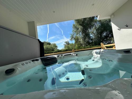 a bath tub with a view of a tornado at Woody Nook Annexe in Pavenham