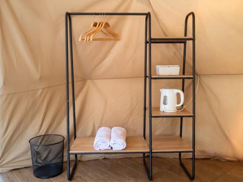 a shelf with towels on it next to a tent at Hanara Private Glamping in Panjadakan