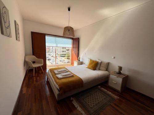 a bedroom with a bed and a large window at Onda Beach House in Cortegaça